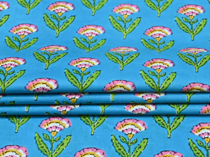 Close-up of blue floral block print cotton fabric with pink and green details