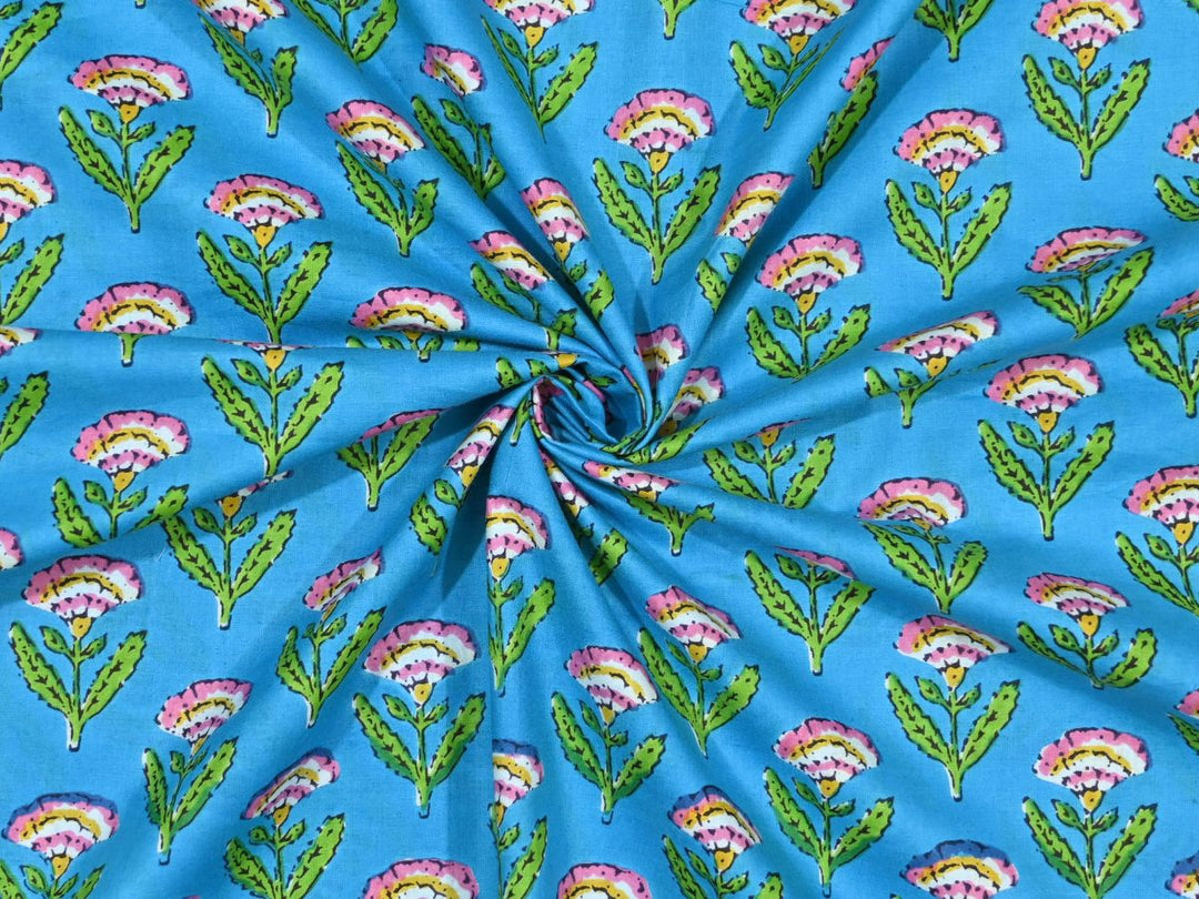 Sky blue block print fabric showing pink and yellow fan-shaped flowers
