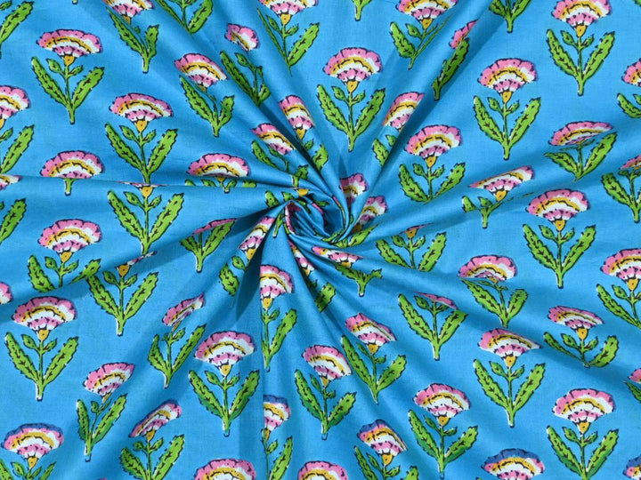 Sky blue block print fabric showing pink and yellow fan-shaped flowers