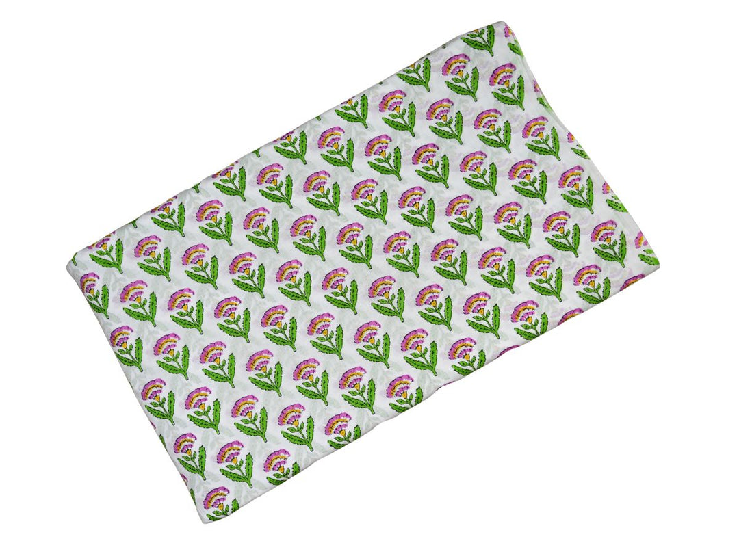 Close-up of pink floral block print cotton fabric with green leaves