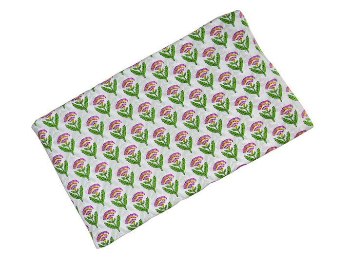 Close-up of pink floral block print cotton fabric with green leaves