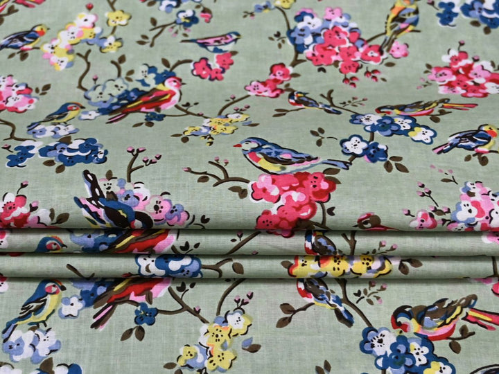 Close-up of bird and blossom print cotton fabric with pink and blue details