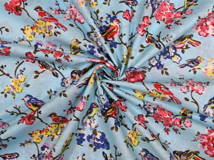 Grey cotton fabric showing multi-colored birds on flowering branches