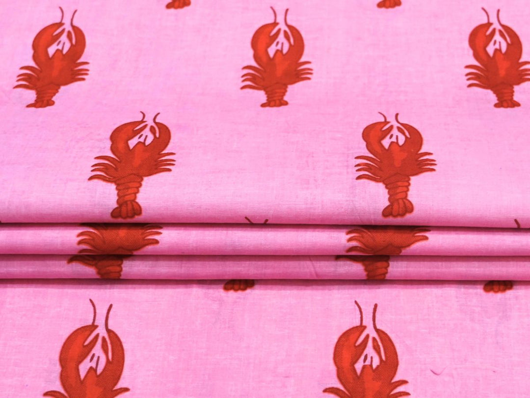 Close-up of pink lobster print cotton fabric with white lobster details