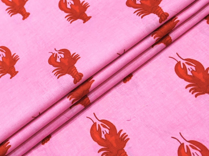 Pink cotton fabric showing red-orange lobster novelty motif