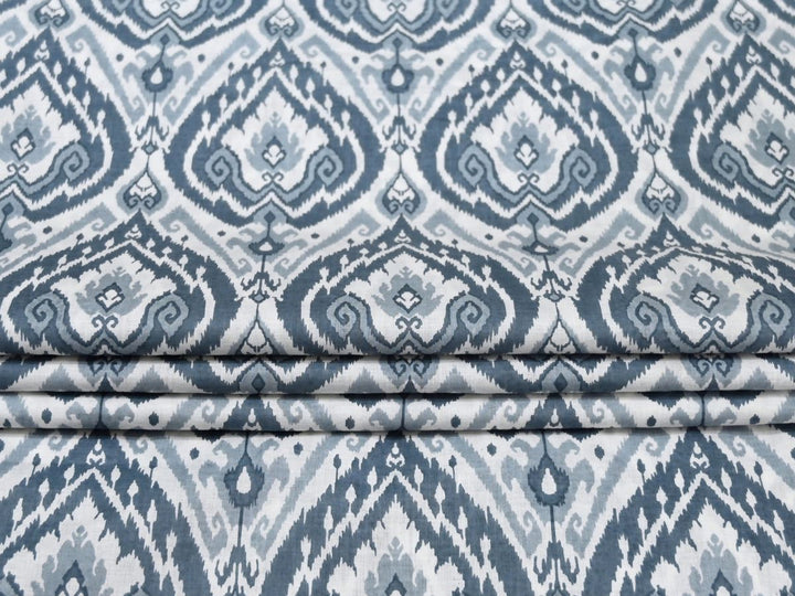 Blue ikat cotton fabric showing feathered-edge diamond motif on white