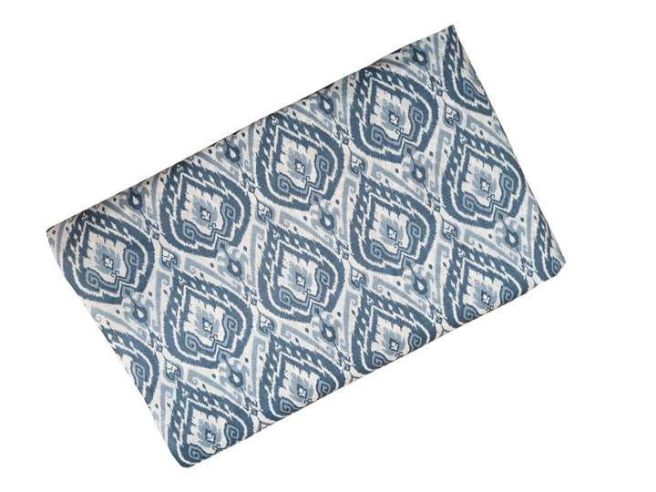 Printed cotton fabric with repeating ikat diamond design and scrollwork