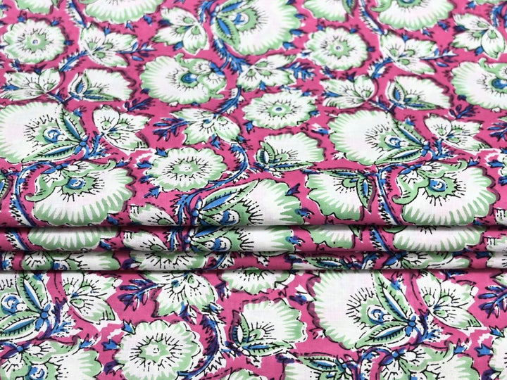 Close-up of pink floral block print fabric with blue outlines and vines