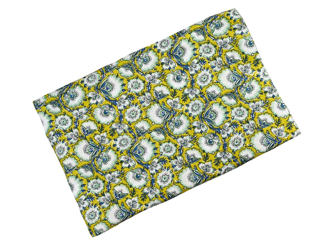 Close-up of yellow floral block print fabric with blue outlines and vines