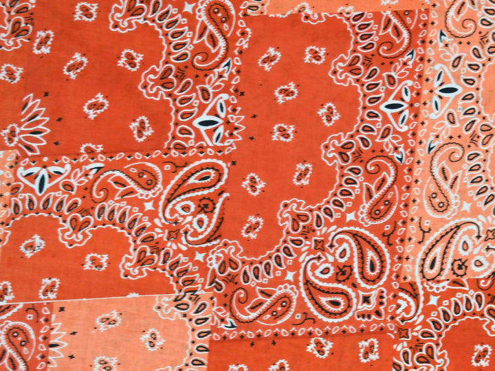 Orange bandana patchwork fabric showing paisley, floral, and star motifs