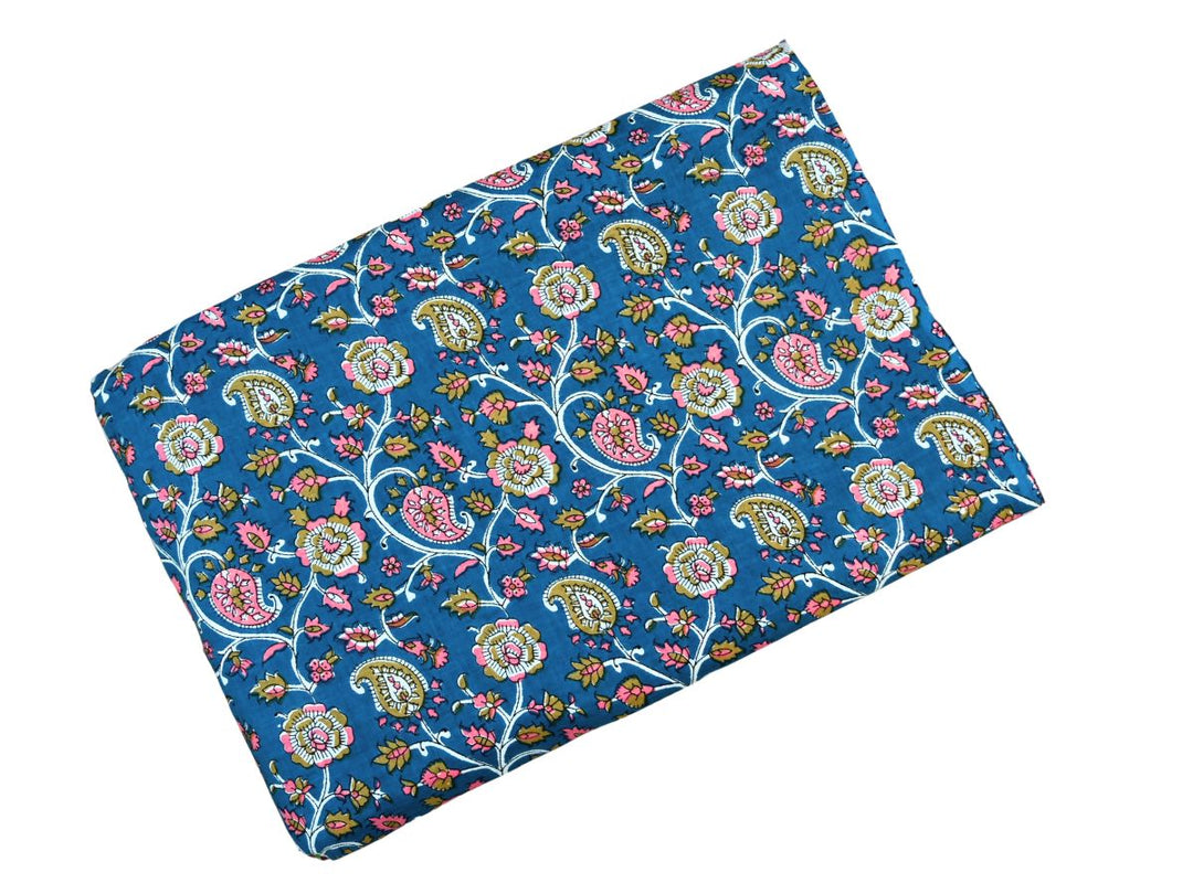 Close-up of deep blue paisley cotton fabric with white outlines and vine details