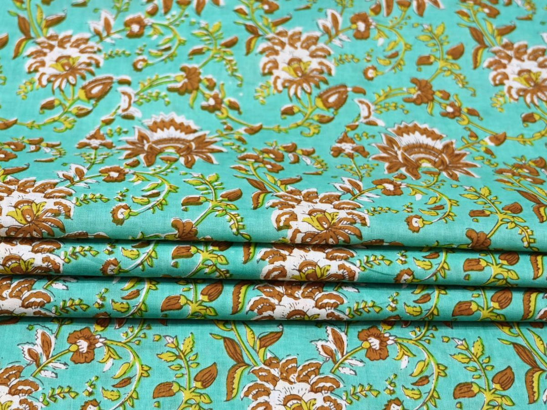 Close-up of turquoise woodblock floral fabric with brown petals and green stems