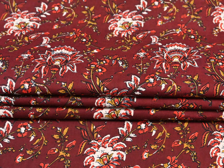 Close-up of maroon block print fabric with scalloped petals and paisley accents
