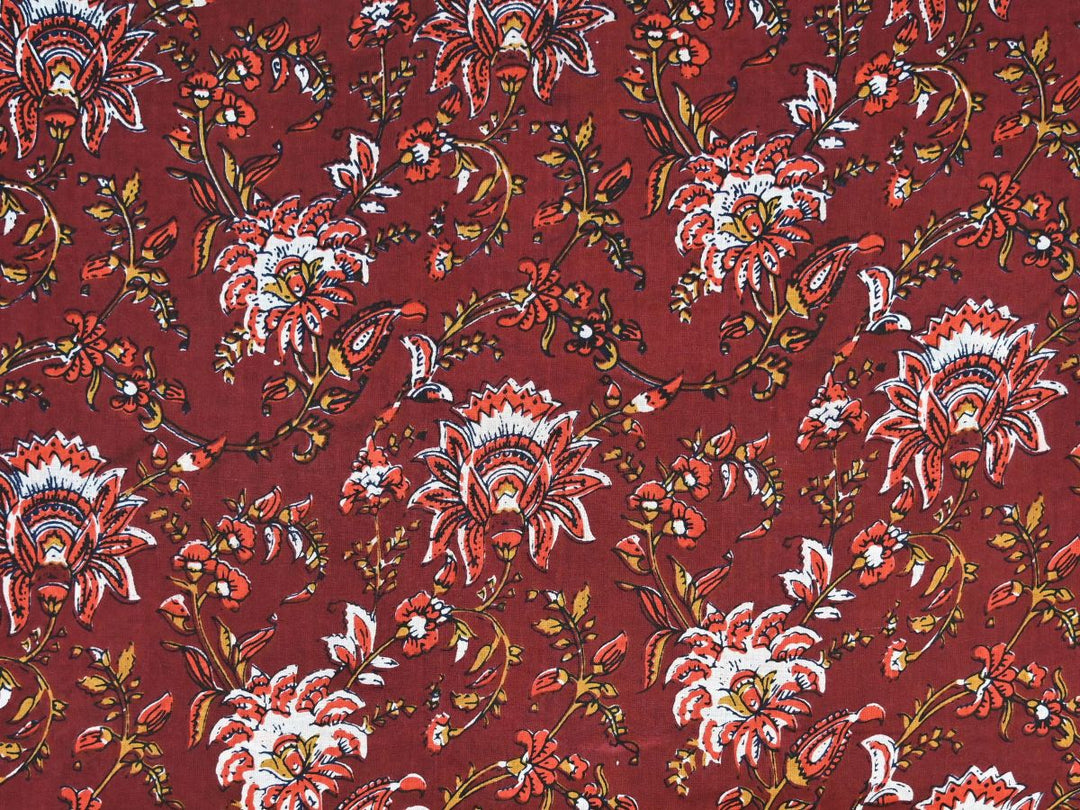 Maroon cotton fabric showing red and white flowers with gold vines