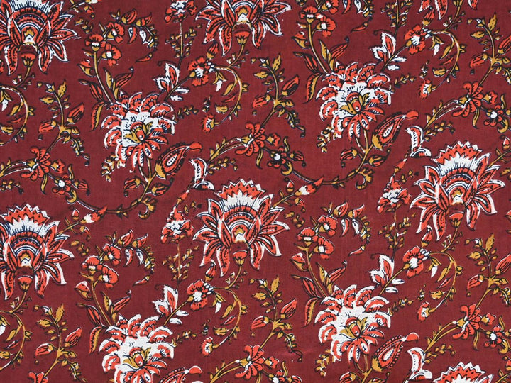 Maroon cotton fabric showing red and white flowers with gold vines