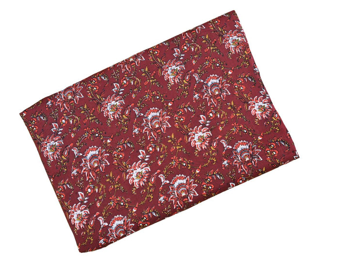 Indian block print fabric with dense botanical pattern on burgundy ground