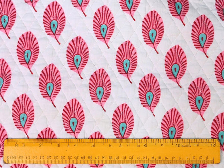 Close-up of pink feather quilted fabric with diamond stitch lines