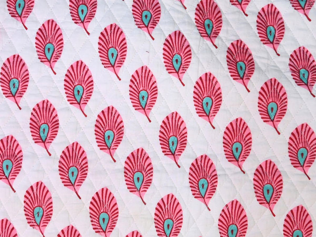Reversible quilted fabric with pink and white striped reverse