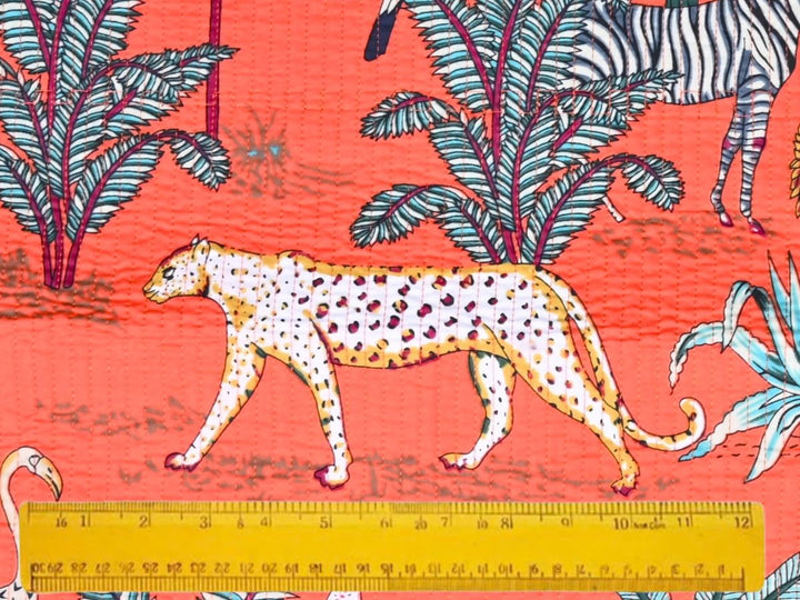 Coral quilted cotton fabric showing cheetah, zebra, and palm motifs