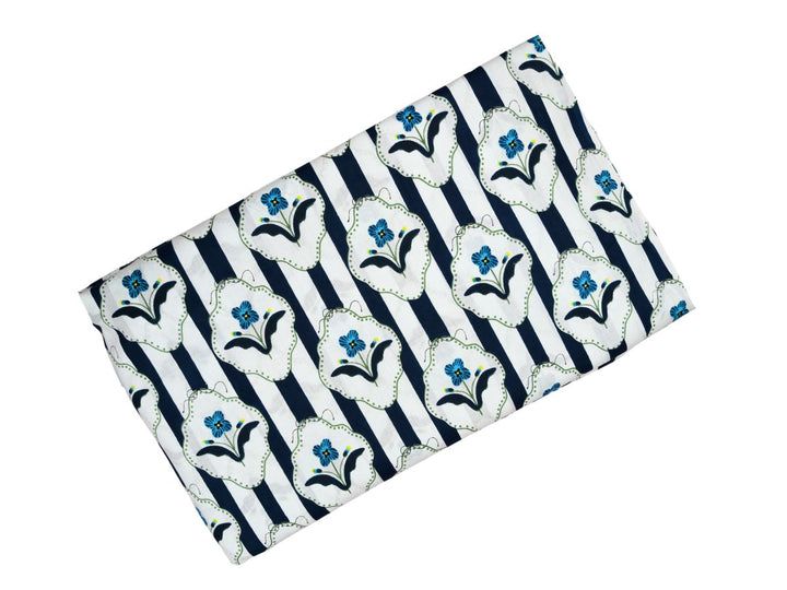 Close-up of navy stripe cotton fabric with blue flower motifs in decorative frames