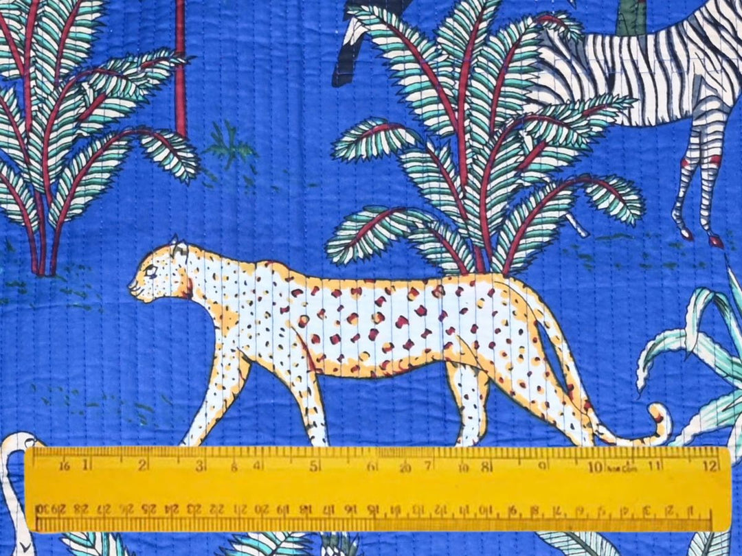 Cobalt blue quilted cotton fabric showing toucan and parrot jungle motifs