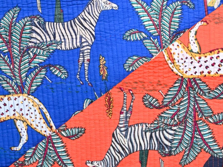 Close-up of blue jungle quilted fabric with teal and magenta foliage details