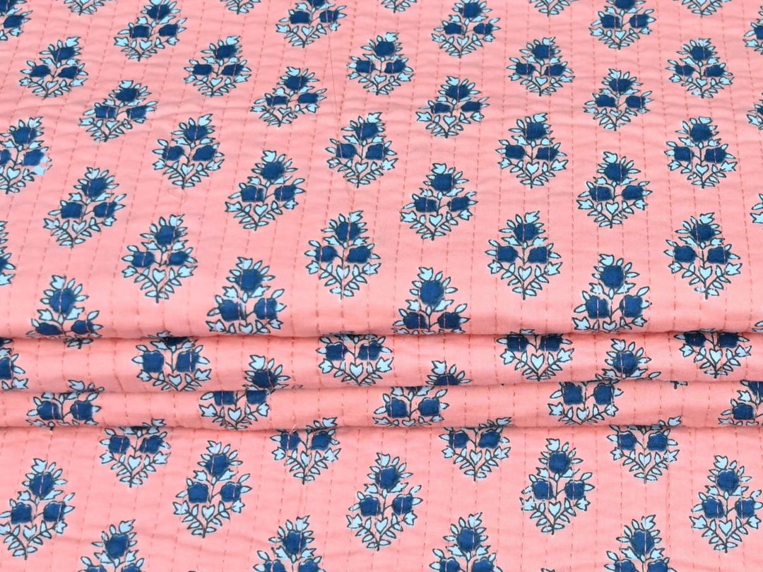 Reversible quilted fabric with peach and white striped reverse