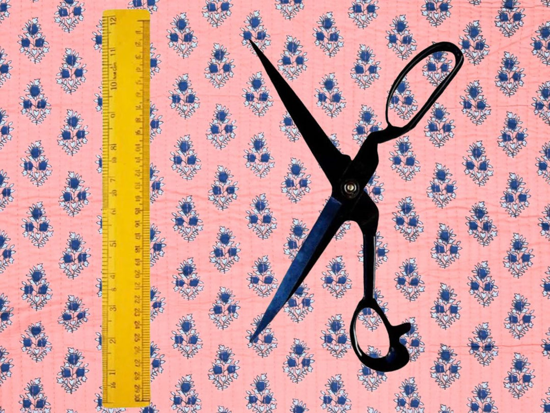 Peach quilted cotton fabric showing small navy flower motifs