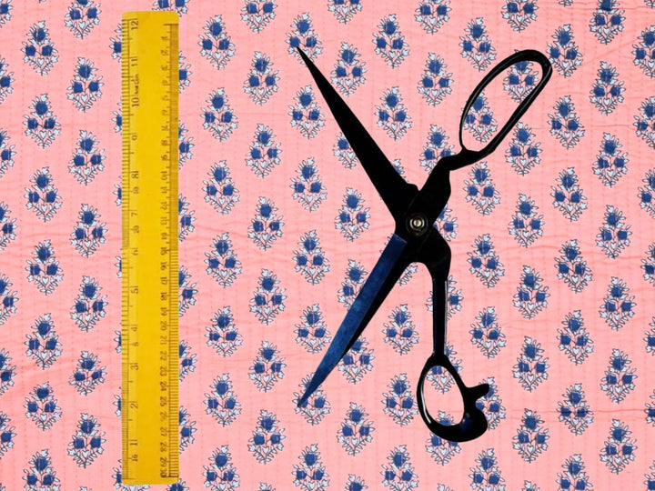 Peach quilted cotton fabric showing small navy flower motifs