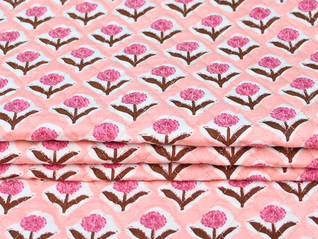 Close-up of peach floral quilted fabric with diamond stitch lines