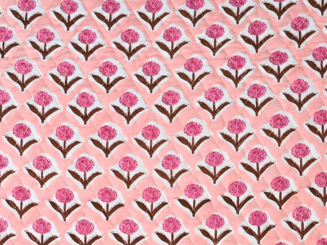 Reversible quilted fabric with peach and white striped reverse
