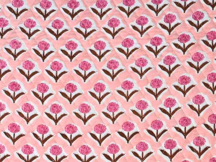 Reversible quilted fabric with peach and white striped reverse