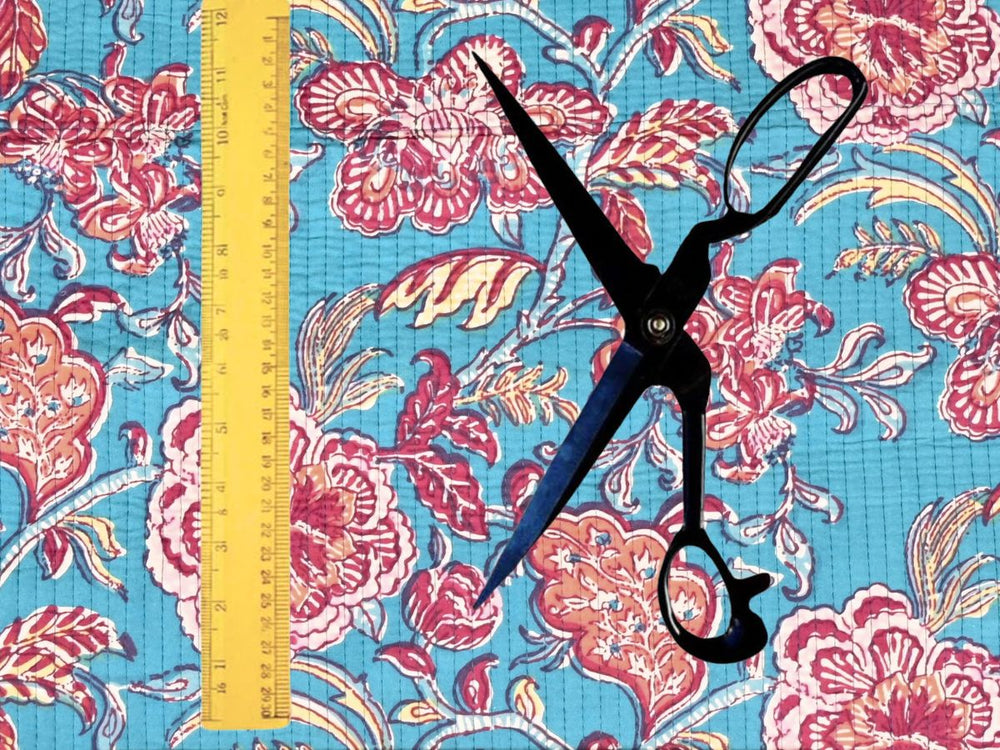 Turquoise quilted cotton fabric showing pink and coral peony blooms
