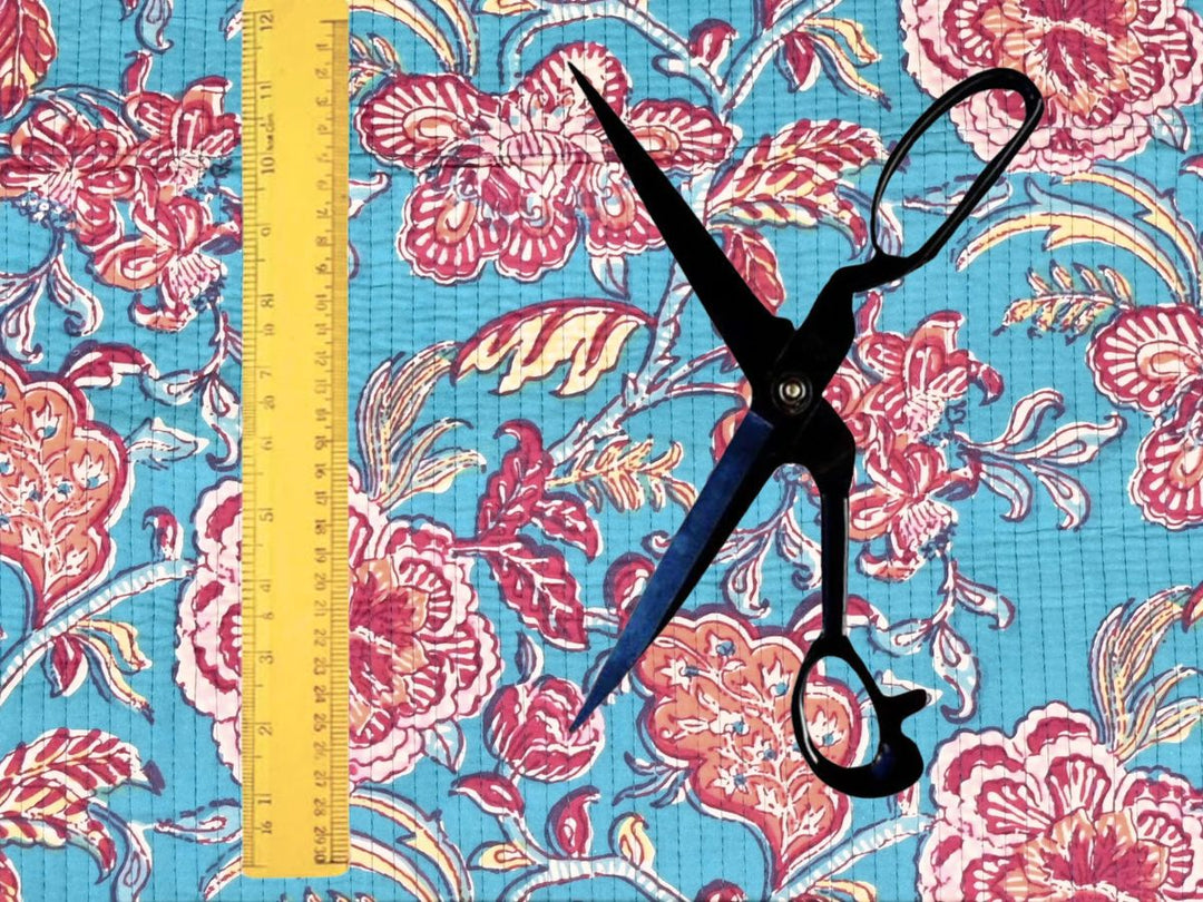 Turquoise quilted cotton fabric showing pink and coral peony blooms