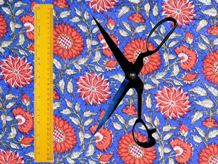 Cobalt blue quilted cotton fabric showing large blooms and sage green foliage