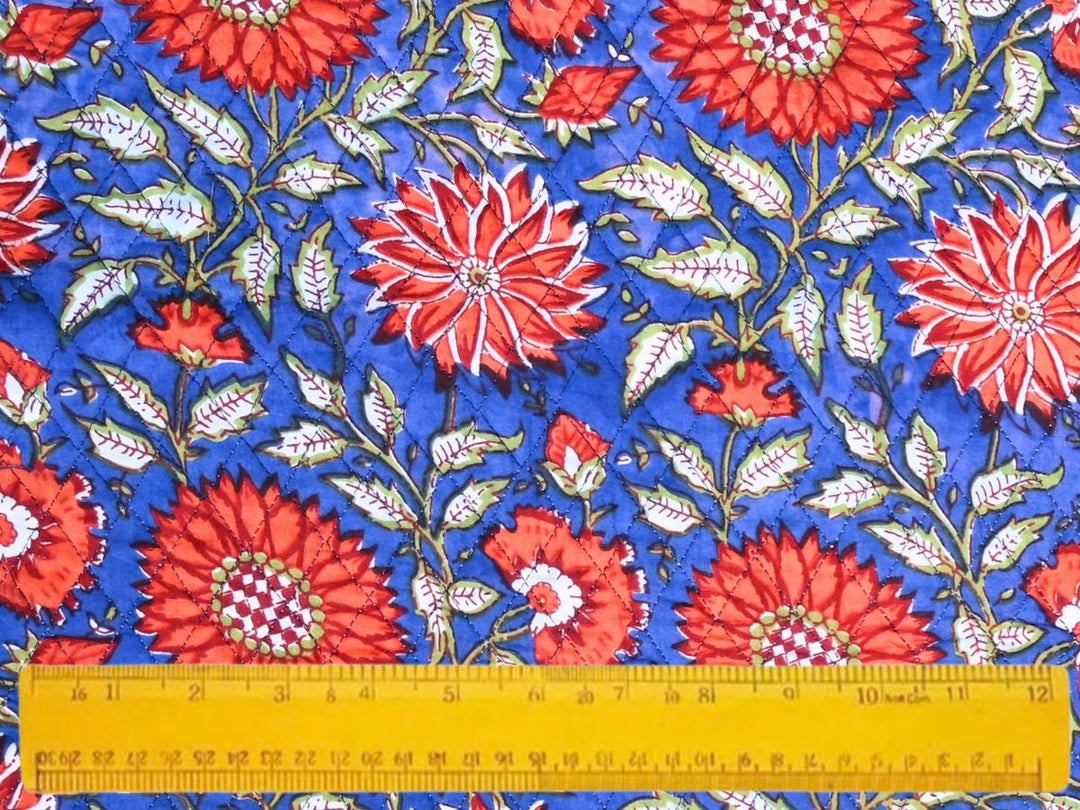 Close-up of cobalt blue quilted floral fabric with diamond stitch lines