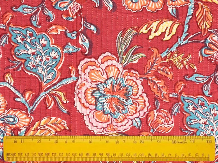Close-up of deep red quilted floral fabric with vertical stitch lines