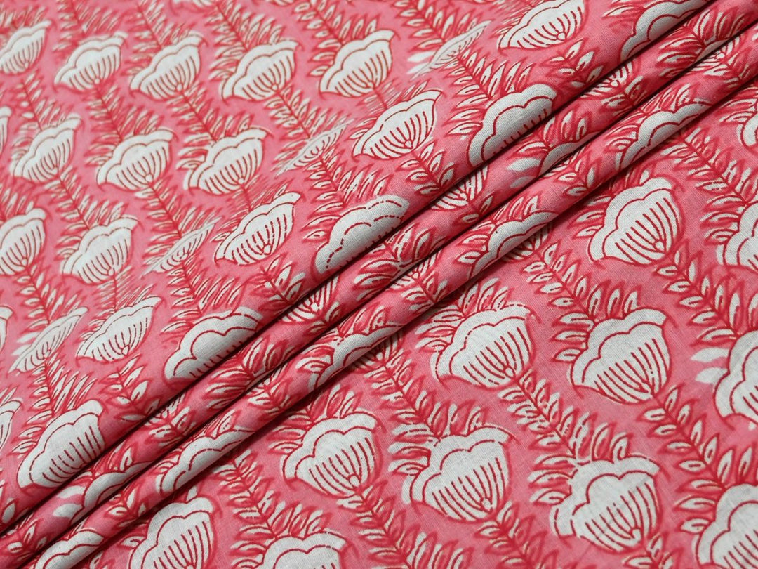 Peach cotton fabric showing scalloped white flowers on fern-like stems