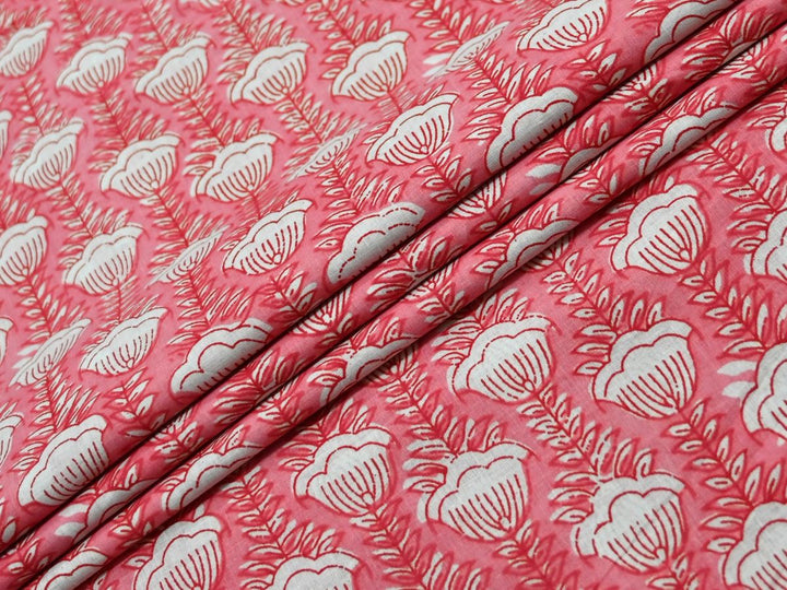 Peach cotton fabric showing scalloped white flowers on fern-like stems