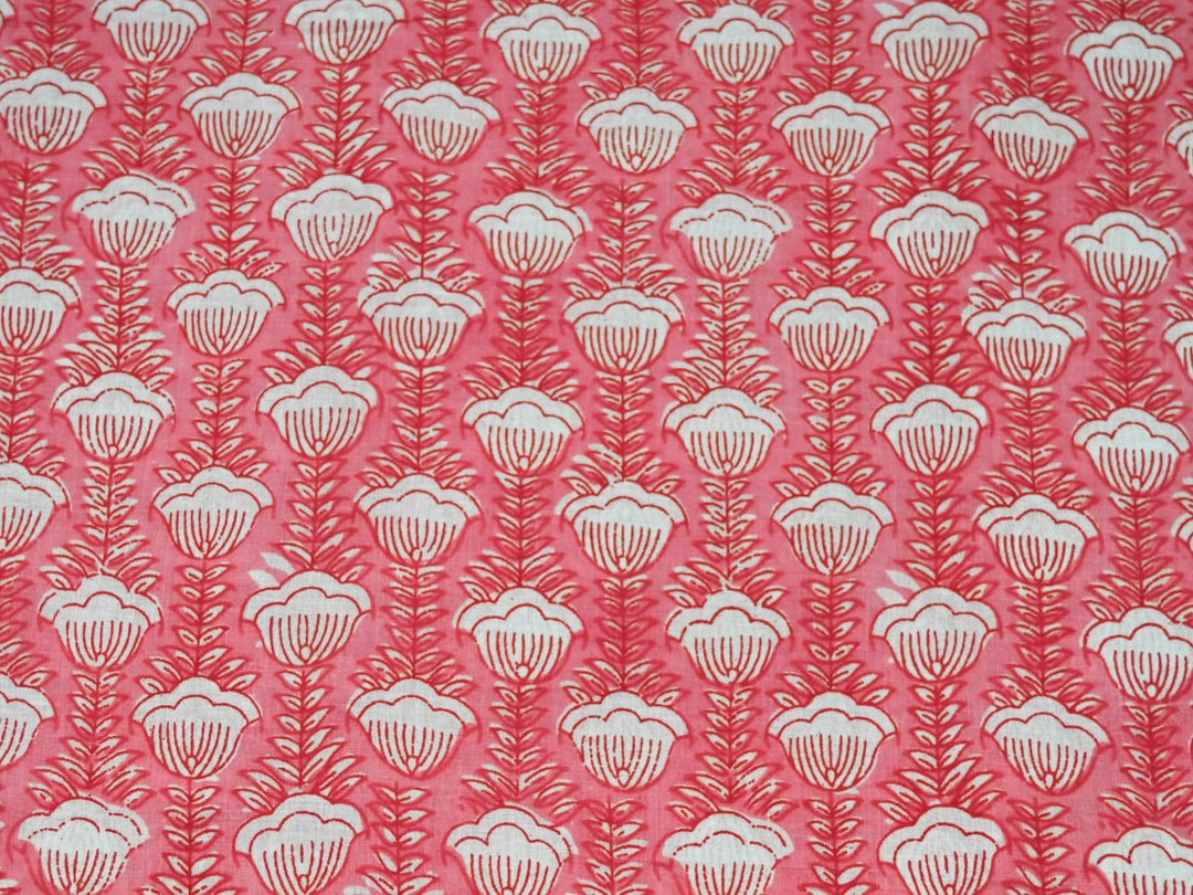 Peach cotton fabric showing scalloped white flowers on fern-like stems