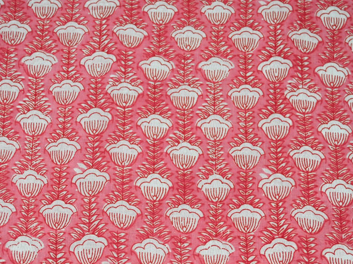 Peach cotton fabric showing scalloped white flowers on fern-like stems