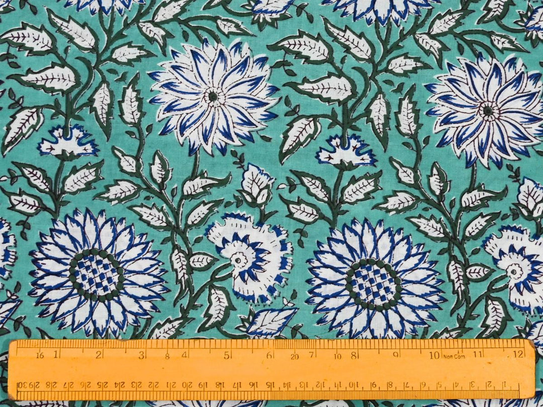 Hand block floral fabric on mint ground with dark green foliage