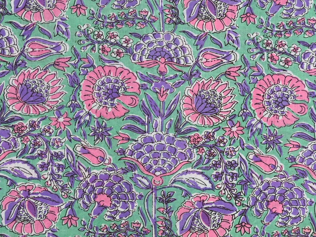 Purple floral cotton fabric by the yard with pink and purple blooms on green