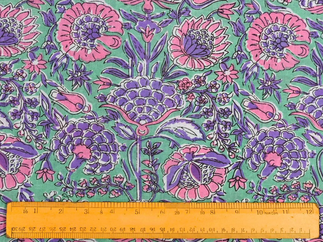 Close-up of purple floral cotton fabric with pink blooms and white accents