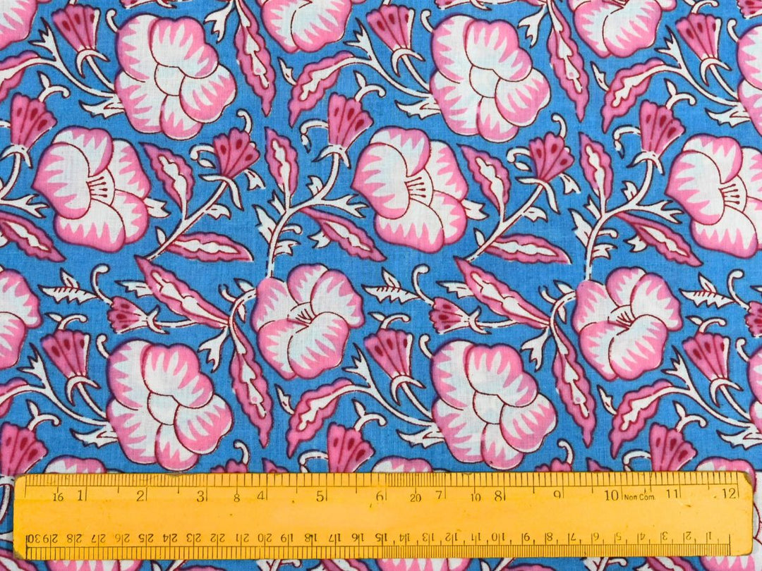 Close-up of blue pink floral cotton fabric with detailed linework and blossom accents