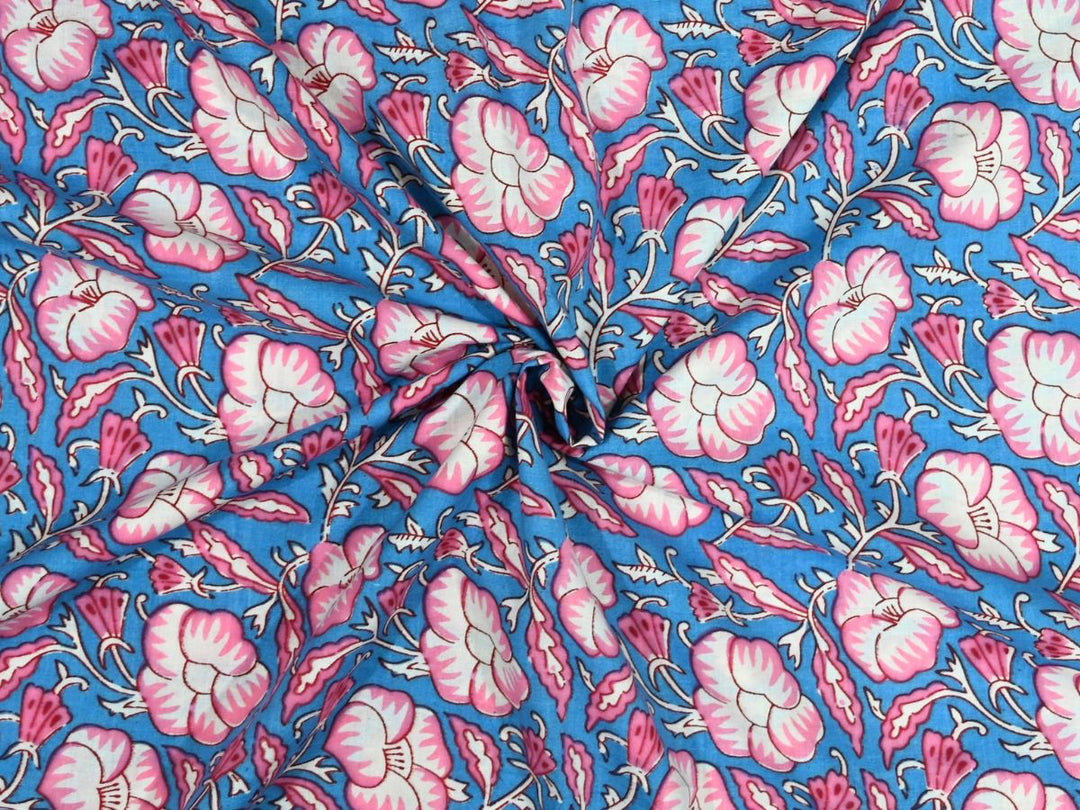 Sky blue cotton fabric showing pink and white flowers with dark pink accents
