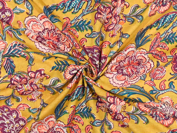 Golden mustard cotton fabric showing coral peony blooms with teal foliage