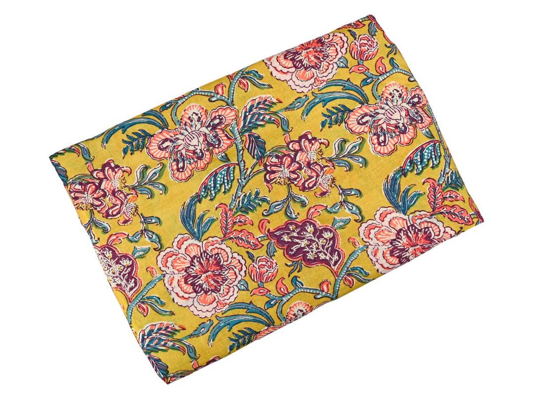 Close-up of mustard yellow floral cotton fabric with detailed linework and dotted textures