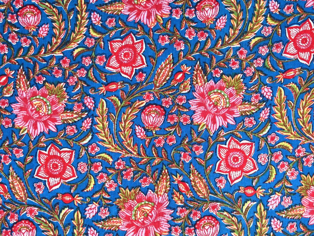 Blue cotton fabric showing peony and star-shaped flowers with olive foliage