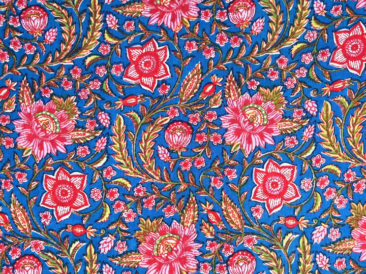 Blue cotton fabric showing peony and star-shaped flowers with olive foliage